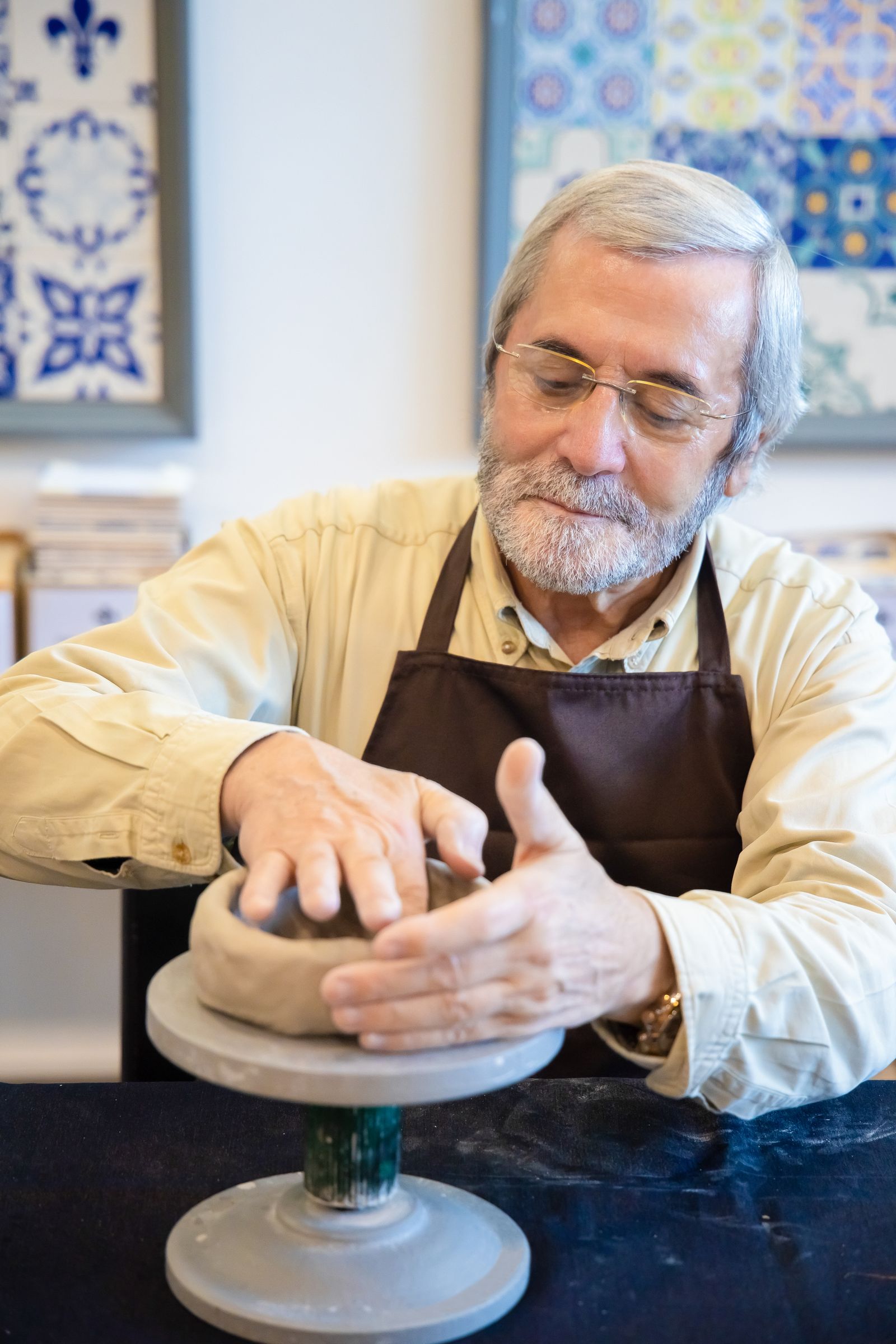 Potter loading ceramic pieces into a top-loading electric kiln for a glaze firing