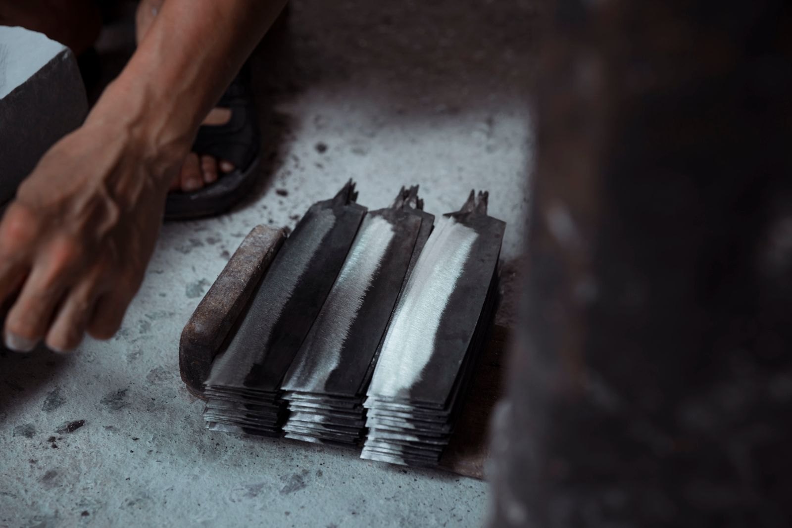 Rough forged blade blanks stacked on a workshop floor