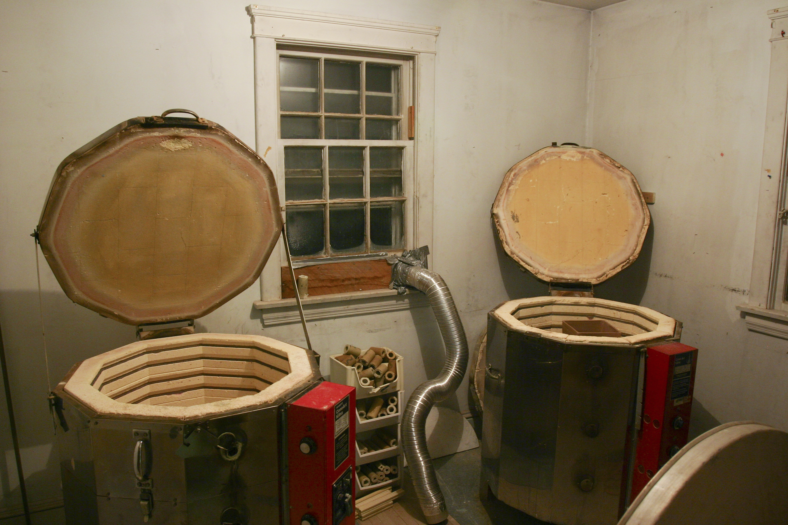 Two top-loading electric kilns in a ceramics studio workspace
