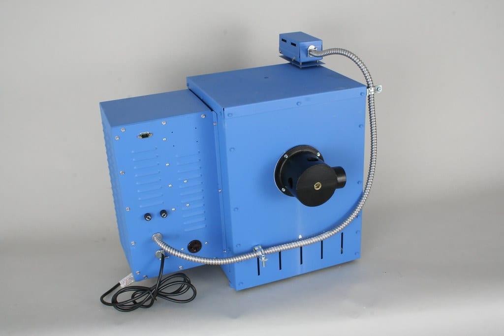 A tabletop electric kiln with a vent collection cup and duct fitted to the back