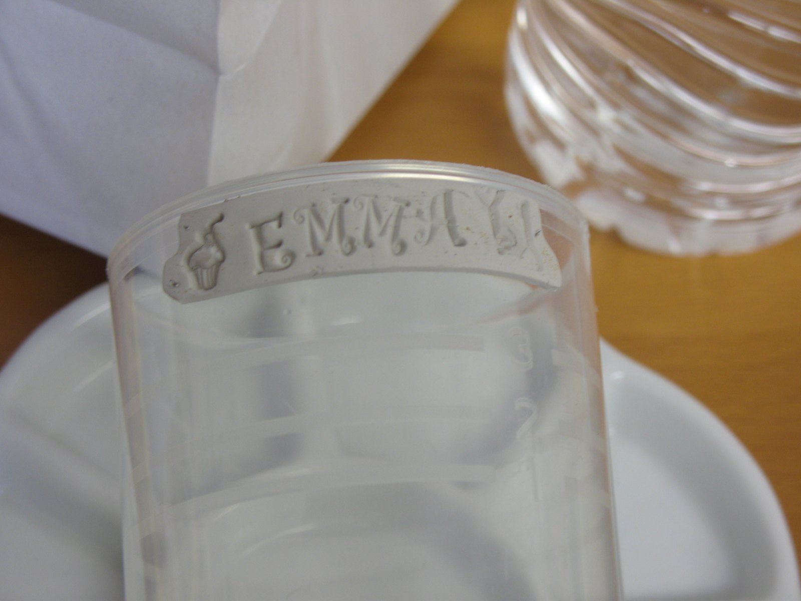 An identification bracelet being shaped from precious metal clay around a drinking glass