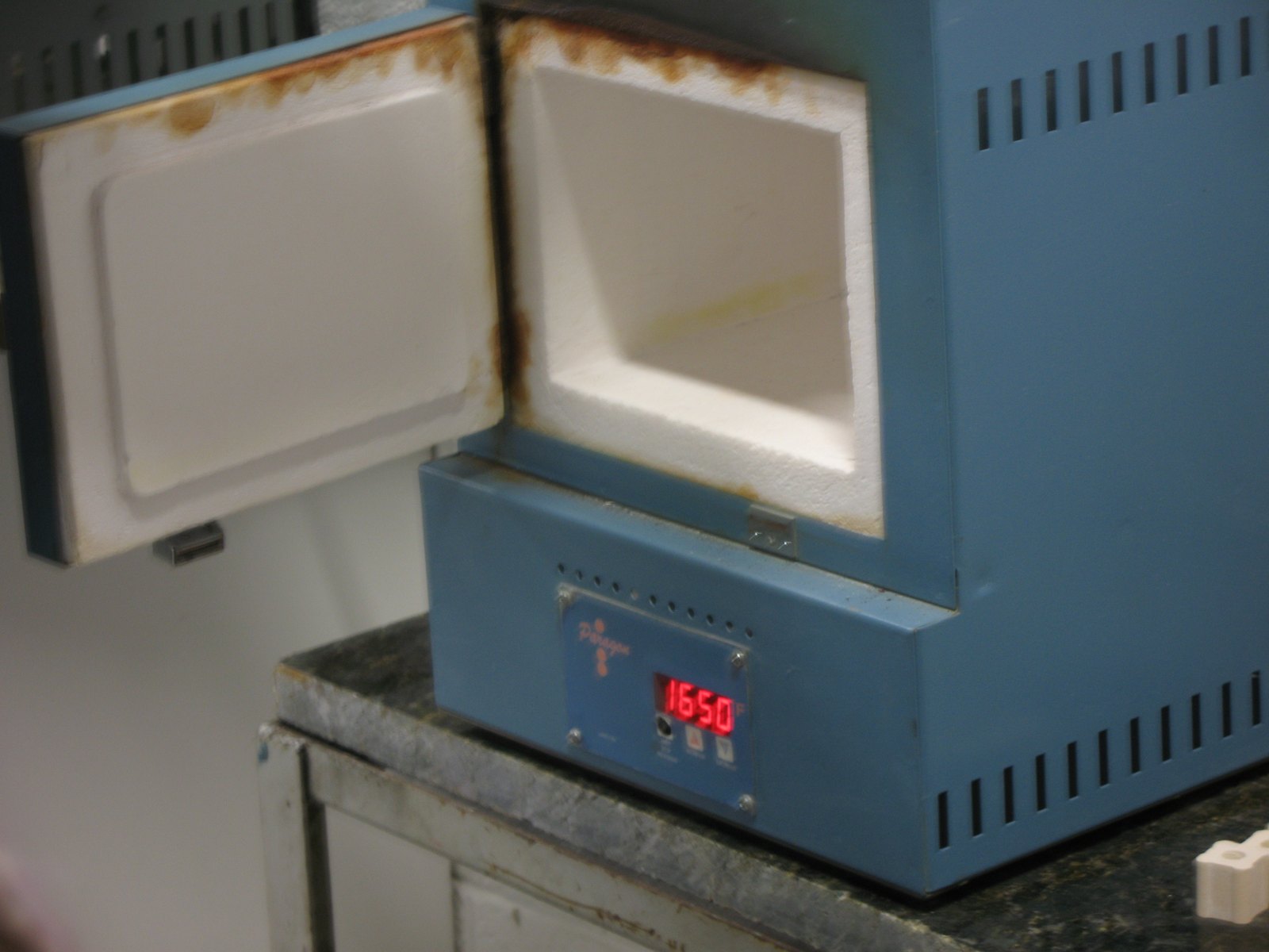 A small blue front-loading Paragon studio kiln with a red digital display reading 1650