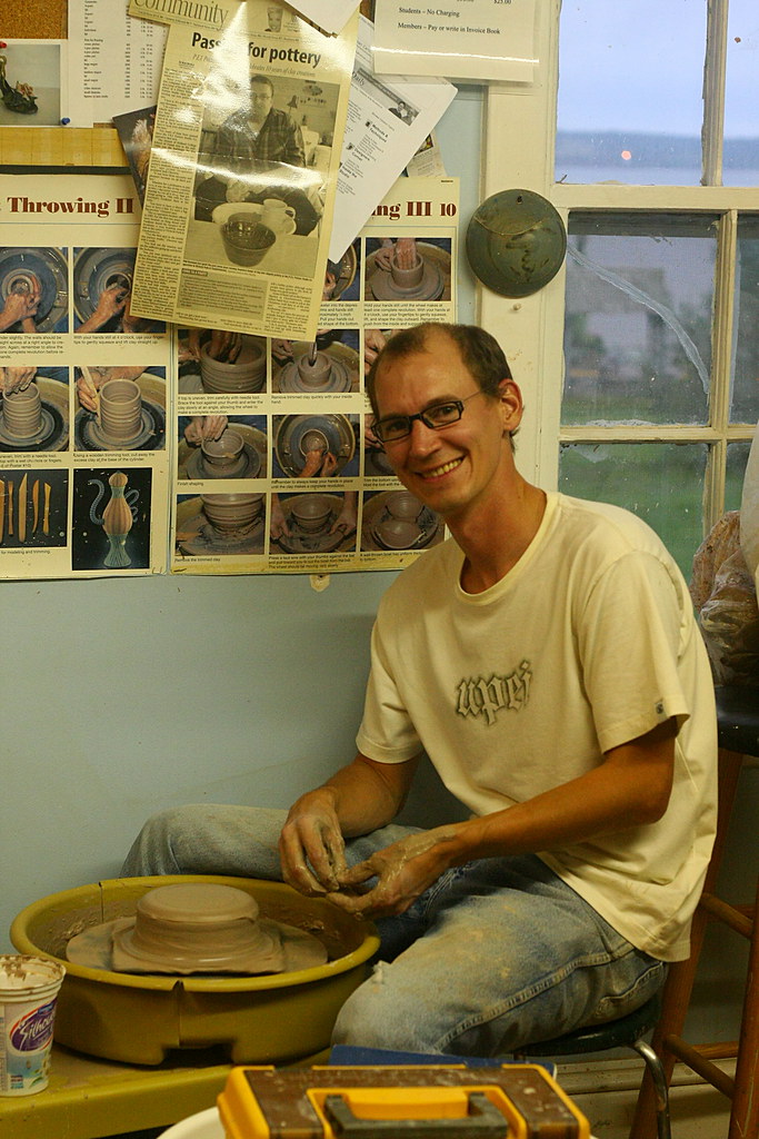 Focused potter at work at a pottery wheel during a throwing session